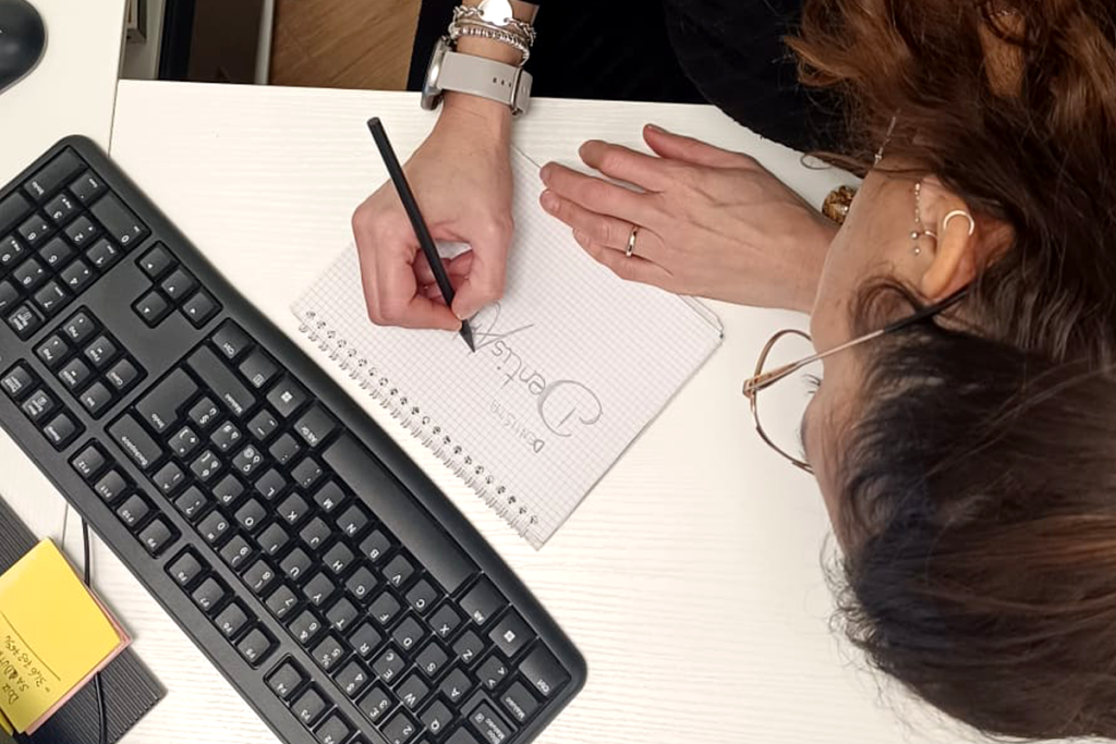 Comunicazione accessibile, team di ad hoc pubblicità che scrive e progetta su un foglio il logo di un cliente per la sua brand identity