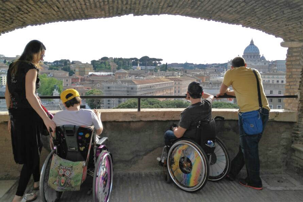 Comunicazione accessibile, team di ad hoc che guarda il panorama di Roma insieme a dei ragazzi disabili